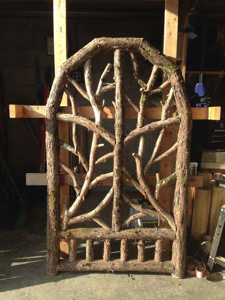Rustic gates built using bark-on trees and branches titled the Beam Gates