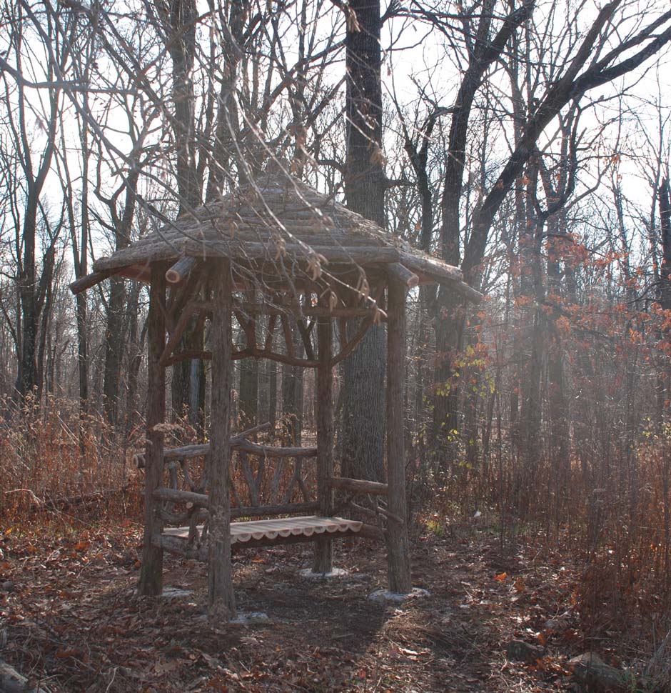 Outdoor rustic covered bench built using bark-on trees and branches titled the South Mountain Shelter