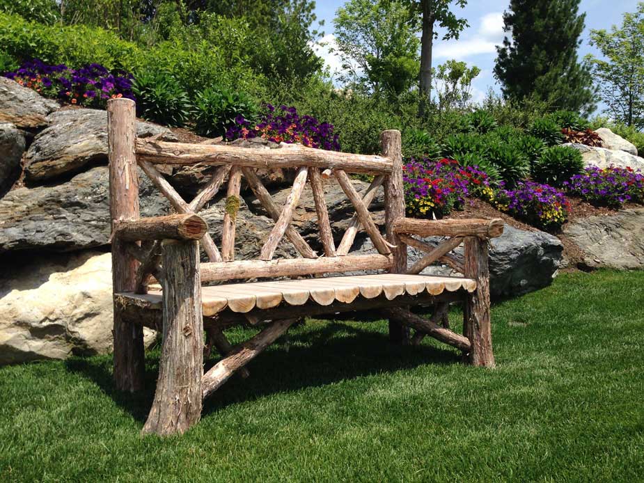 Outdoor rustic garden bench built using bark-on trees and branches titled the Milan Bench