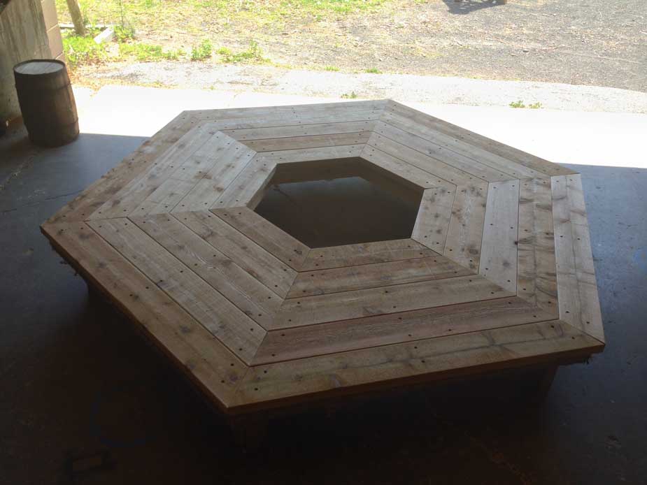 Outdoor rustic bench built around a tree using bark-on trees and branches titled the Alice Austen Tree Bench