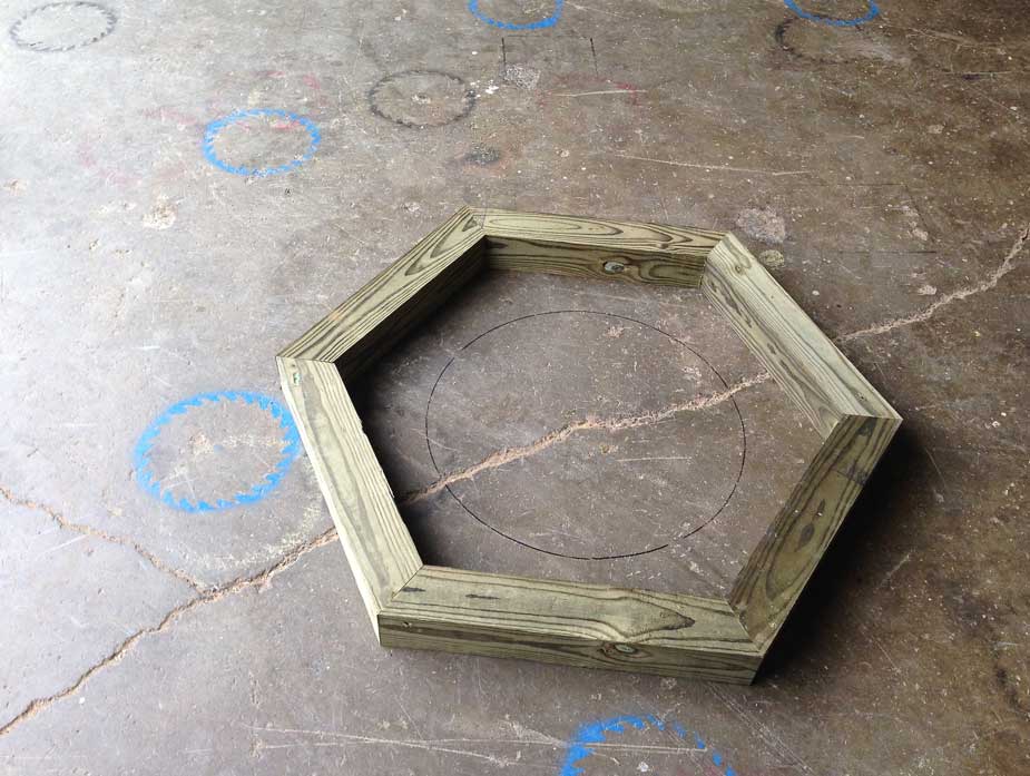 Natural wood bench built around a tree constructed using trees and branches titled the Alice Austen Tree Bench