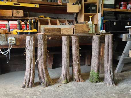 Outdoor rustic garden bench built using bark-on trees and branches titled the Maverick Bench