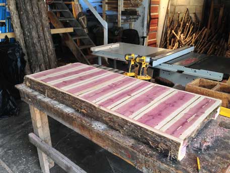 Exterior twig bench built from cedar logs titled the Maverick Bench