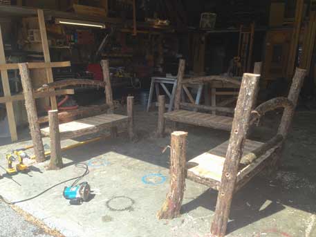 Natural wood bench built with trees and branches titled the Maverick Bench