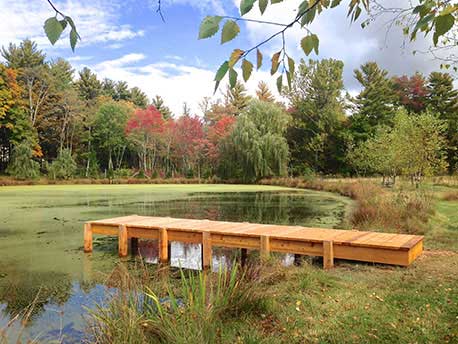 Rustic gazebo and dock built in the rustic style using logs and branches titled the Williams Dock Shelter