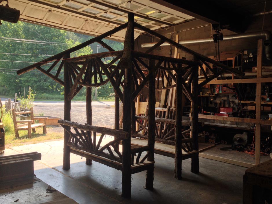Rustic garden pavilion built using bark-on trees and branches titled the Briarcliffe Shelter