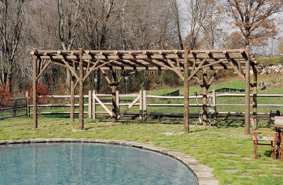 Rustic natural arbor made from bark-on cedar logs, twigs, and branches titled the Concord