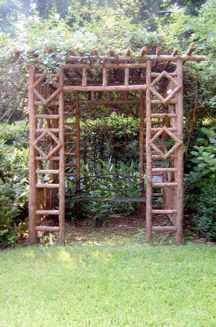 Natural wood rustic arbor built with trees and branches titled the Diamond