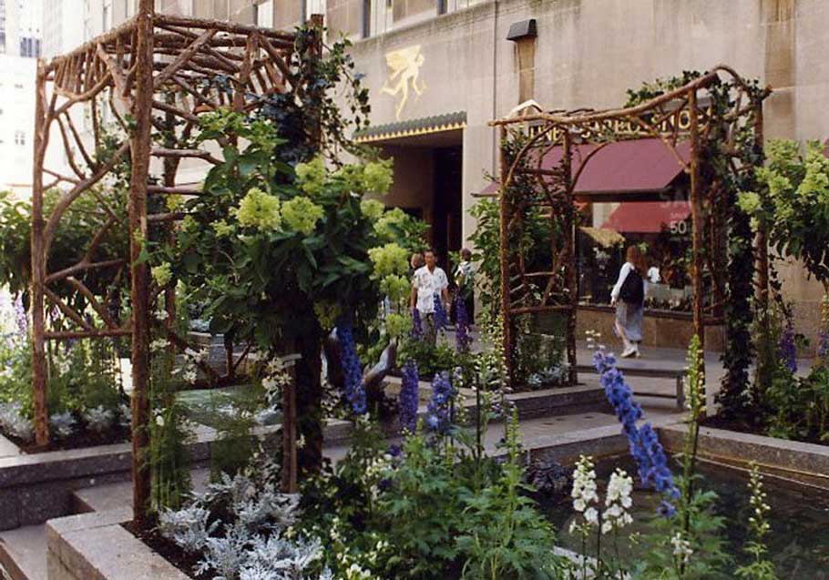 Rustic natural arbor made from bark-on cedar logs, twigs, and branches titled the Rockefeller Center 1 & 2