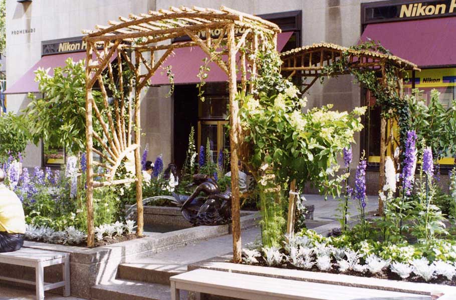 Rustic natural arbor made from bark-on cedar logs, twigs, and branches titled the Rockefeller Center Sunburst