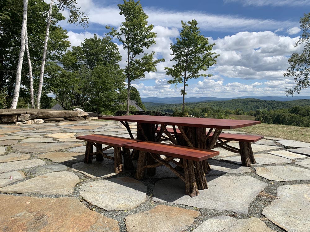Outdoor rustic dining table built using bark-on trees, branches, and african mahogony boards titled the Lamondo Table