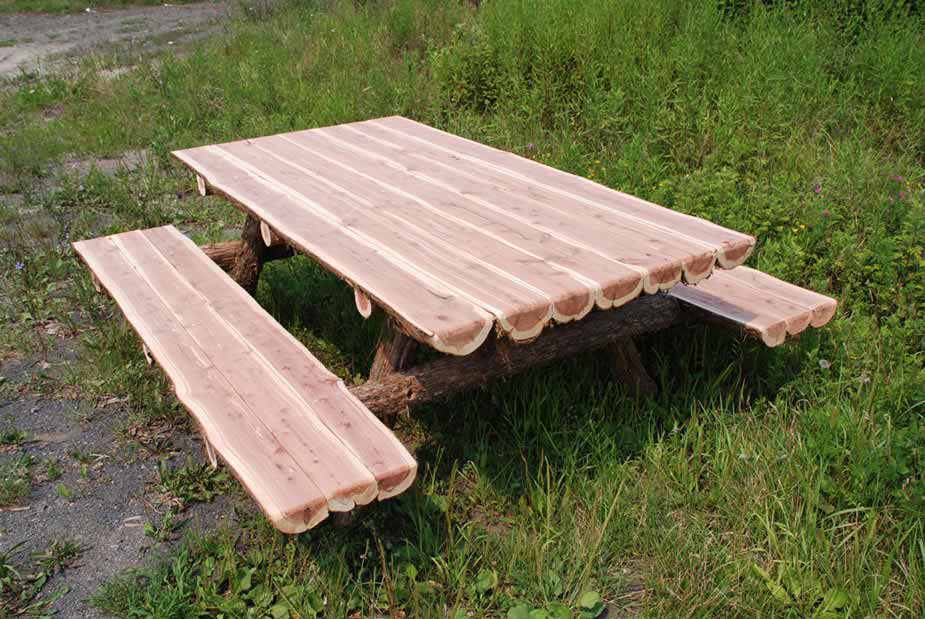 Outdoor rustic picnic table built using natural cedar logs titled the Half-Round Picnic Table