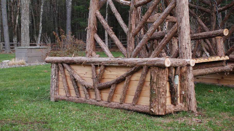 A large flower planter with a removable insert constructed using bark-on cedar trees and branches