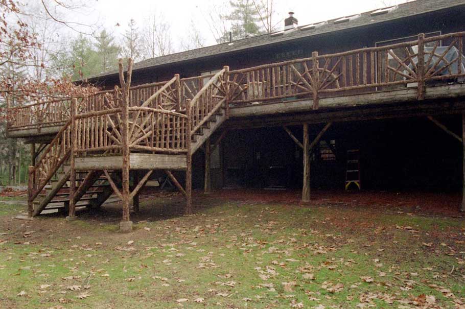 Rustic deck railings built using bark-on trees and branches titled Gold Deck Rails