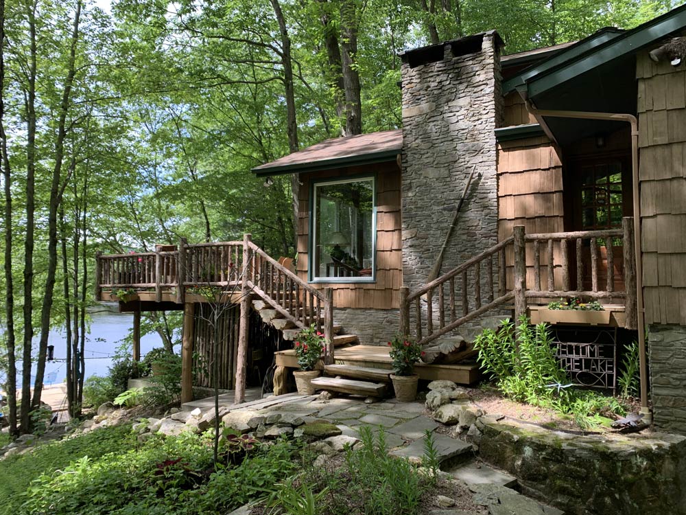 Rustic deck railings custom built using cedar trees and branches titled Holmes Deck Railings