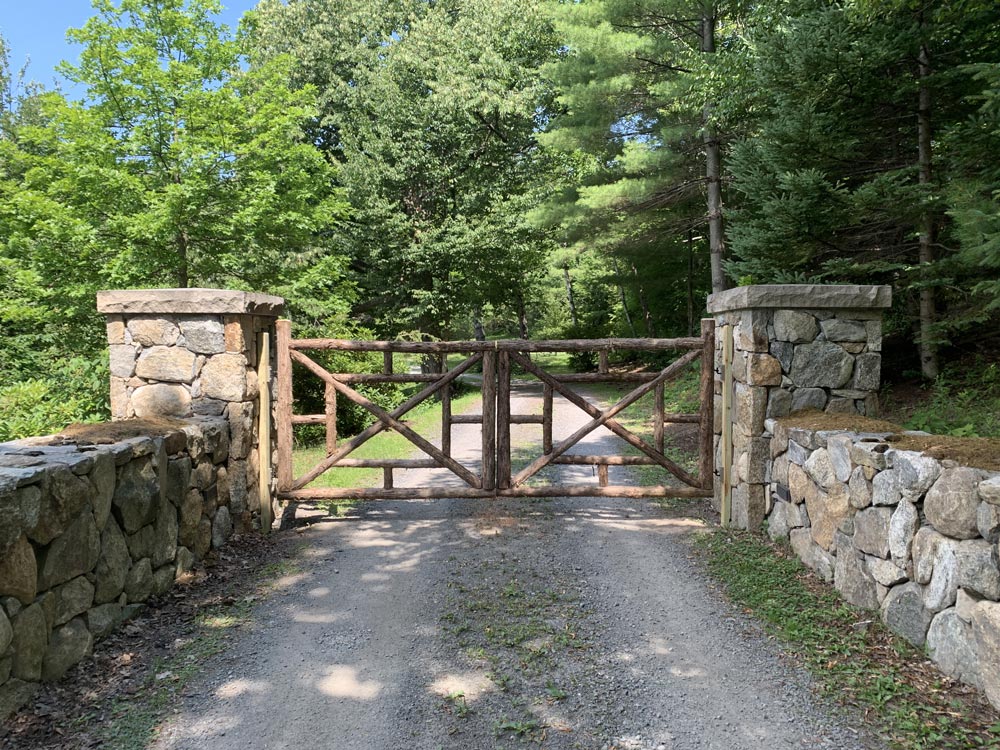 Rustic driveway gates custom built using cedar trees and branches titled Huguenot Driveway Gates
