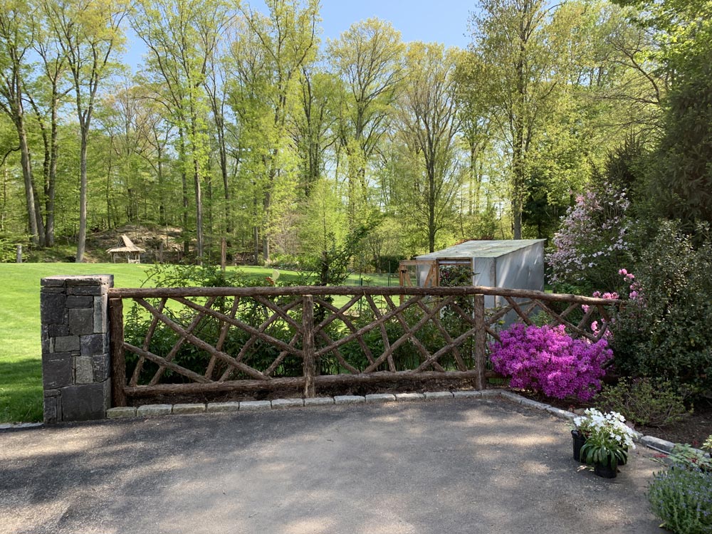 Rustic fencing custom built using cedar trees and branches titled Ossining Fencing