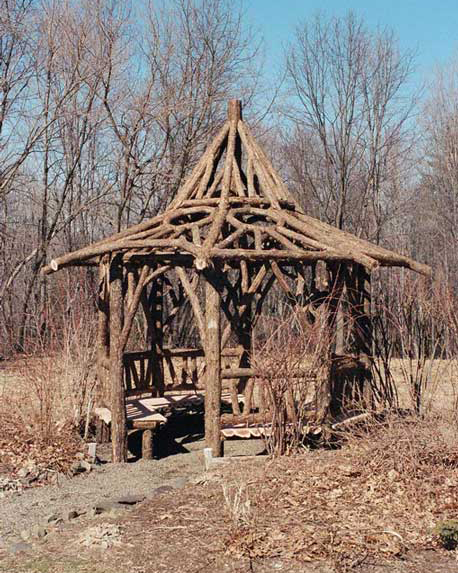 A gazebo built in the rustic style using logs and branches installed at Chiu's Summerhouse