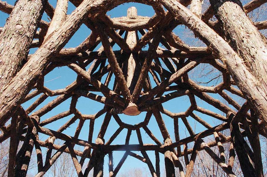 A detail of a gazebo roof built in the rustic style using logs and branches installed at Chiu's Summerhouse
