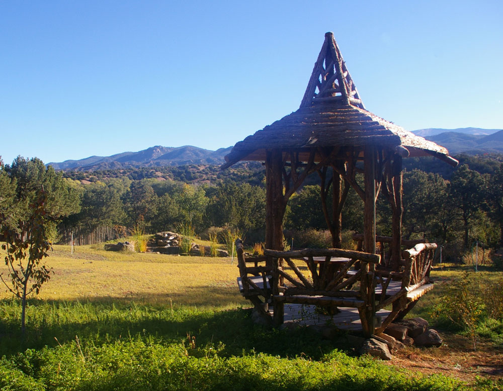 Natural wood gazebo with interior seating built with trees and branches titled the Santa Fe Gazebo