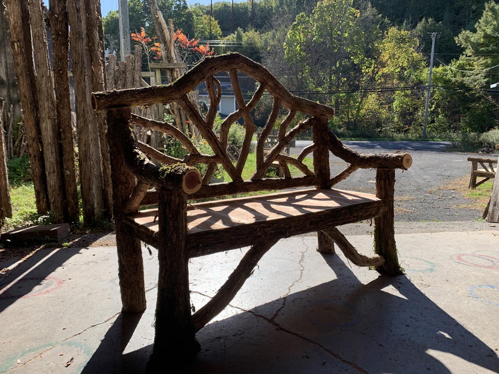 Rustic bench custom built using cedar trees and branches titled the Garrison