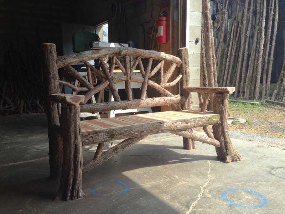Natural wood bench built with trees and branches titled the Maverick
