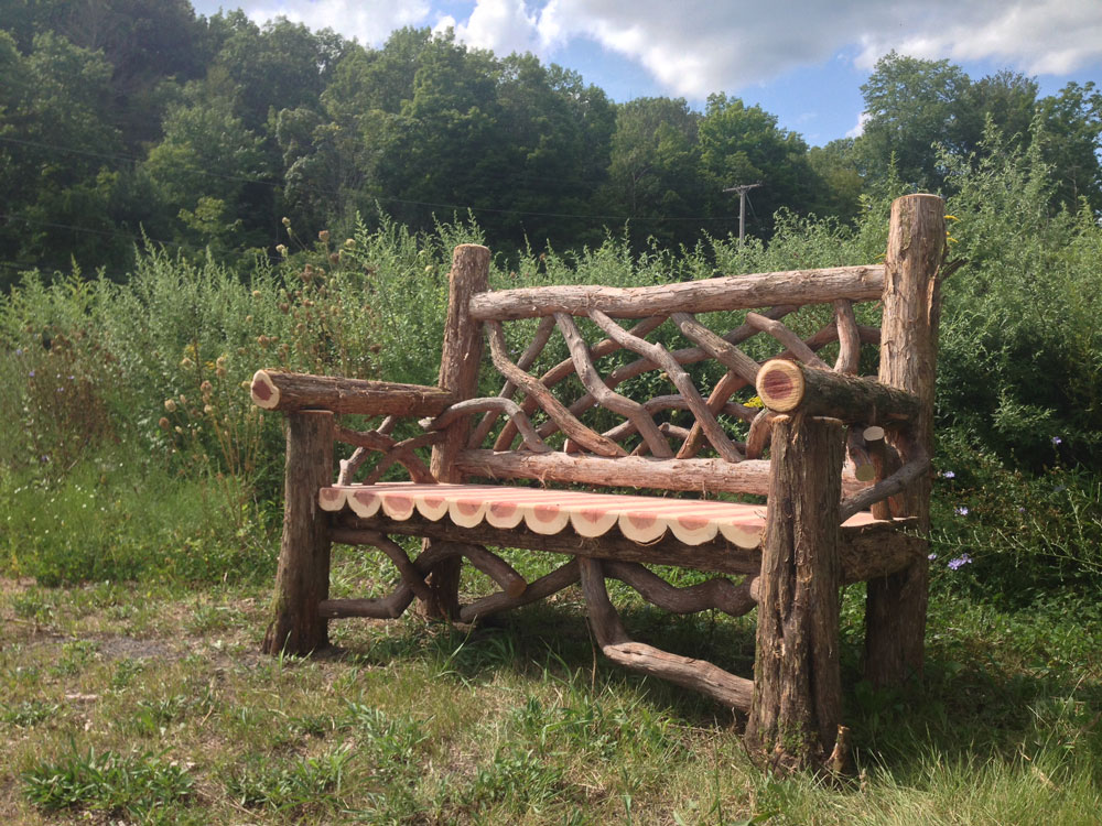 Outdoor rustic garden bench built using bark-on trees and branches titled the Mohonk Bench