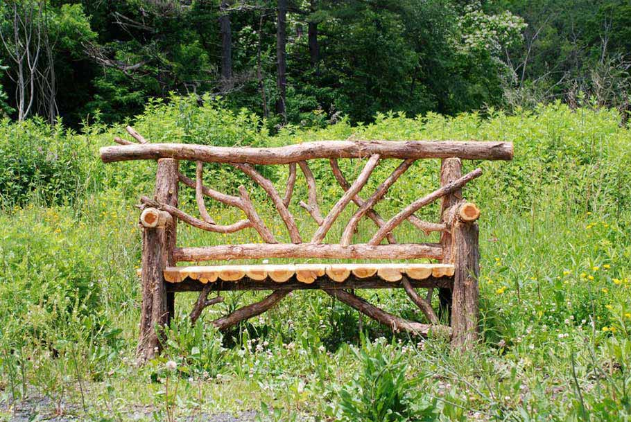 Outdoor park bench built in the rustic style using logs and branches titled the Bedford