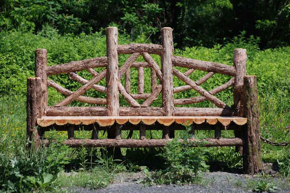 Natural wood bench built with trees and branches titled the Viewpoint